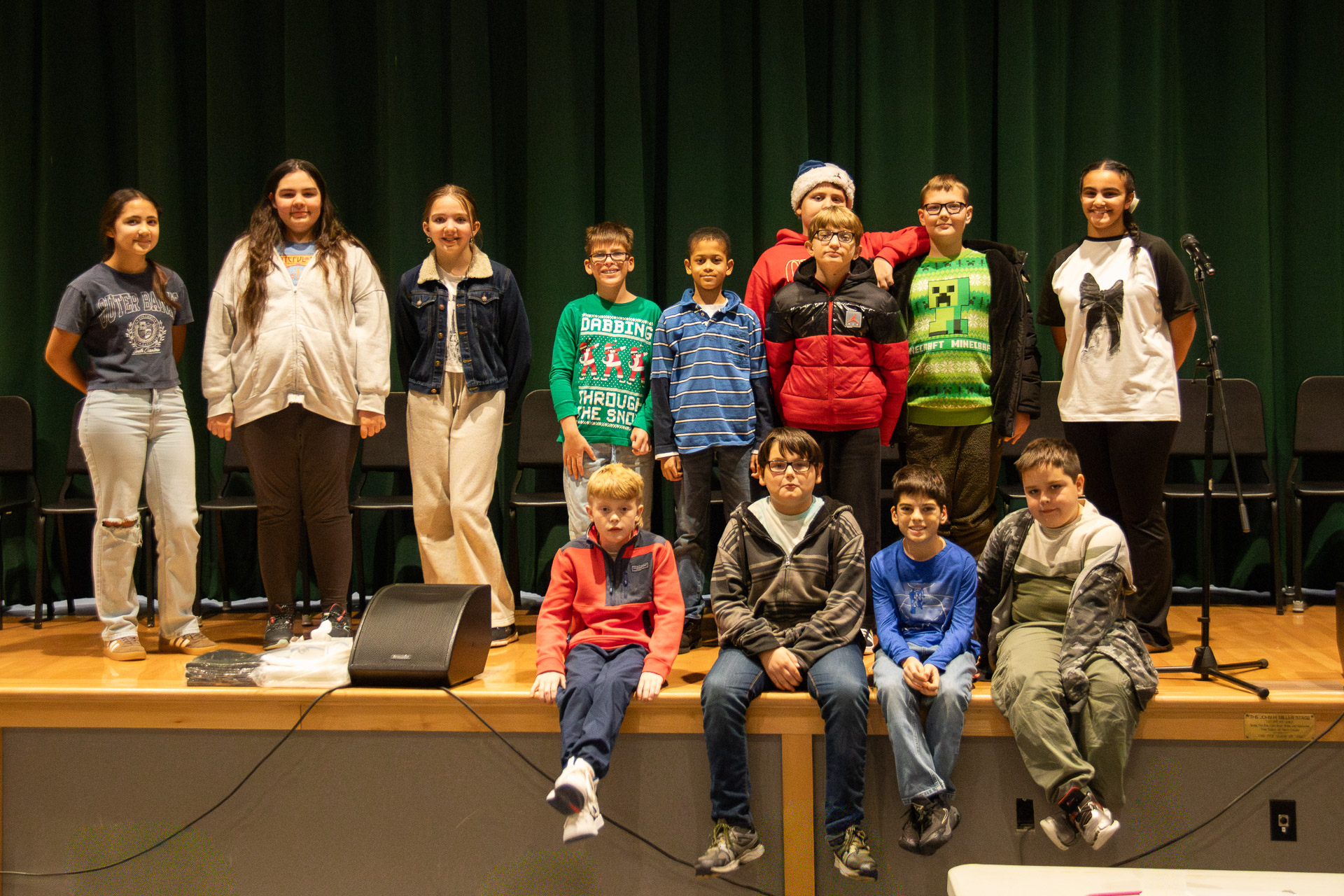 4th through 6th grade spelling bee participants group photo on stage.